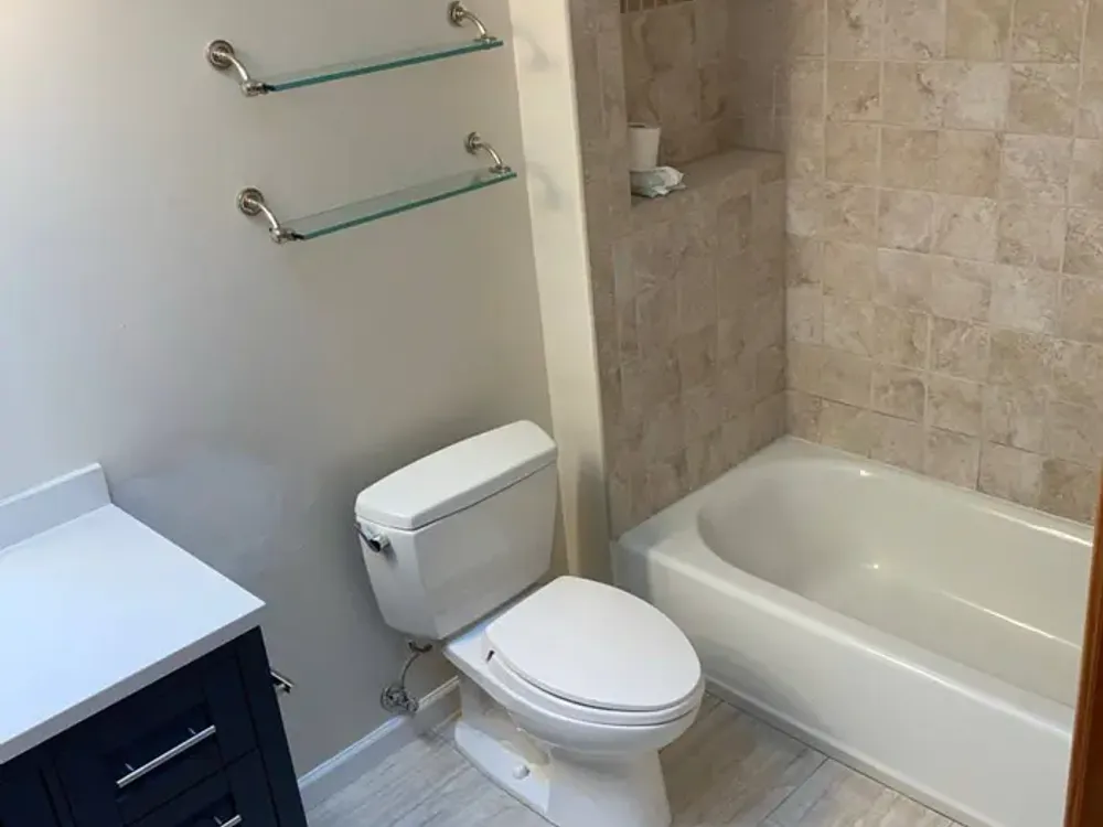 Hall bathroom with a tub and a dark vanity