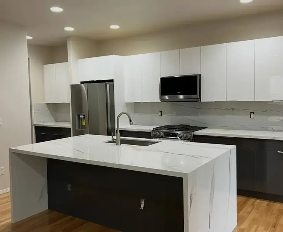 Super white quartzite countertop kitchen remodel with dark tile floor
