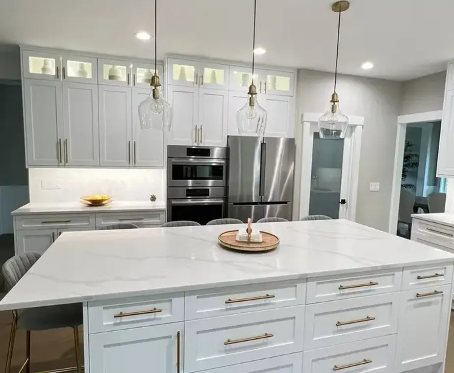 Quartz island countertop with bar stools and gold pendant lights