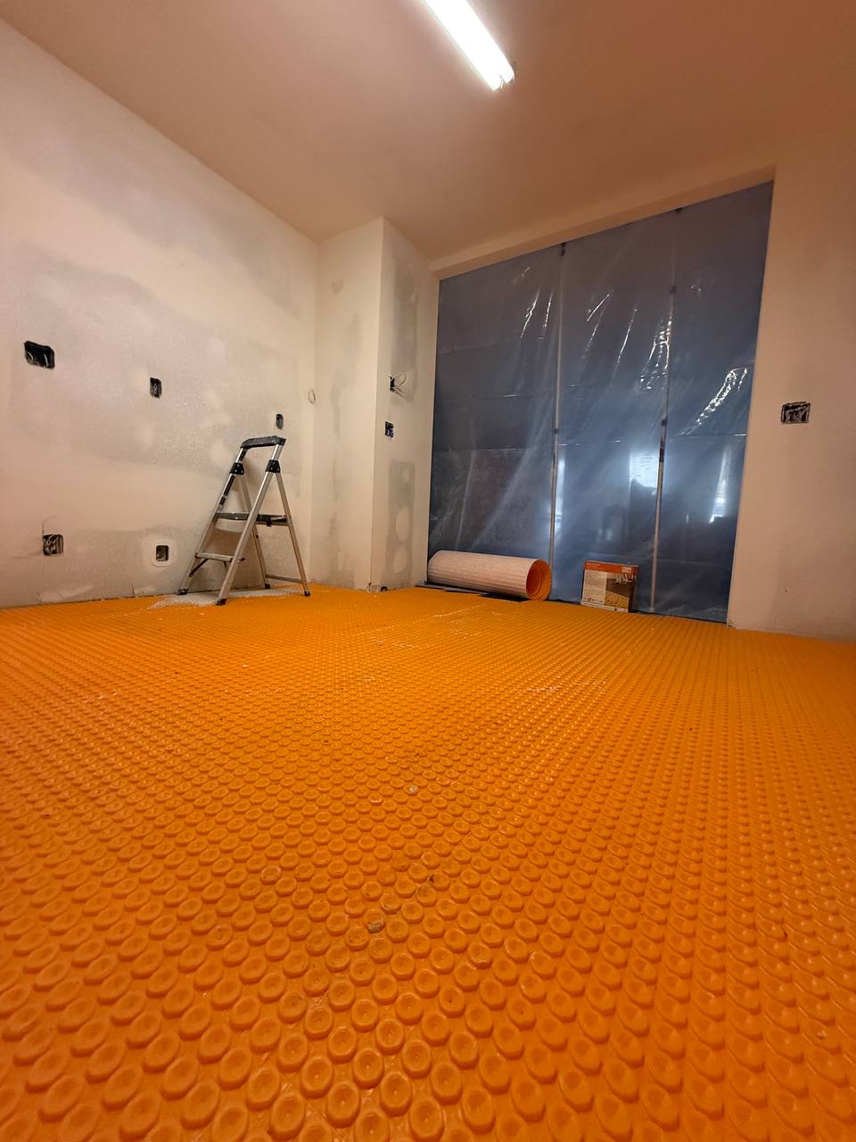 Electric radiant heating mat laid before tile