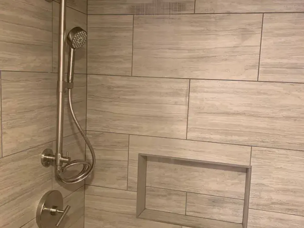 Wood-look tile shower with a niche and a handheld shower
