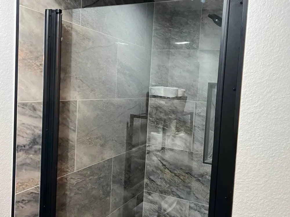 Glass shower door with black hardware