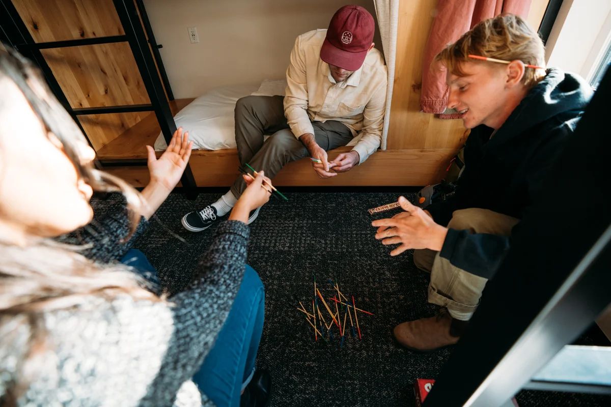 Friends playing game in Family Suite in Kinship Landing Local Boutique Hotel with To go snacks from Homa Cafe and Bar Restaurant