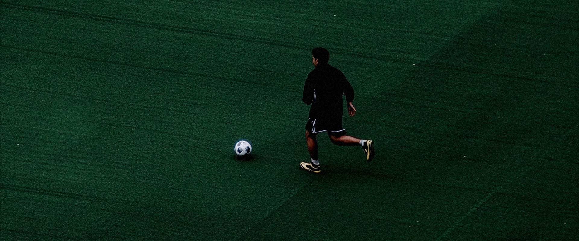 Soccer player kicking a soccer ball on a field