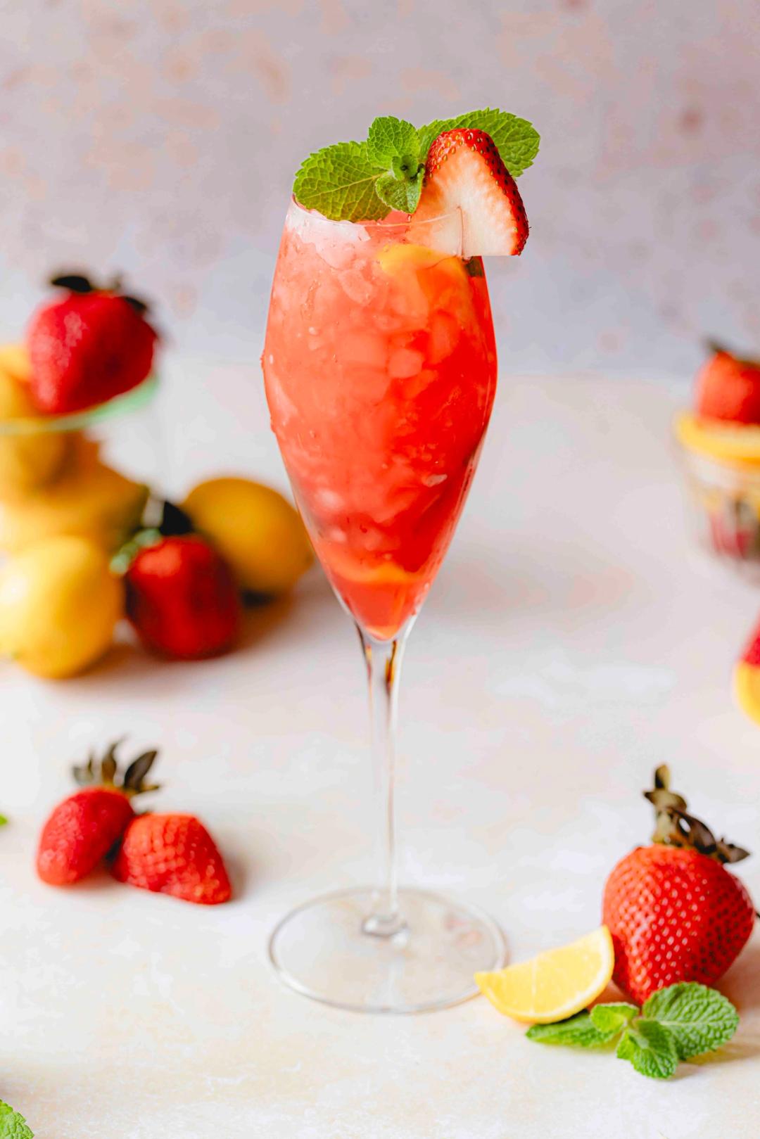 Minty Strawberry Lemonade Cooler made with Perricone Farms Strawberry Lemonade and peppermint-infused coconut water, served over crushed ice with strawberry and mint garnish