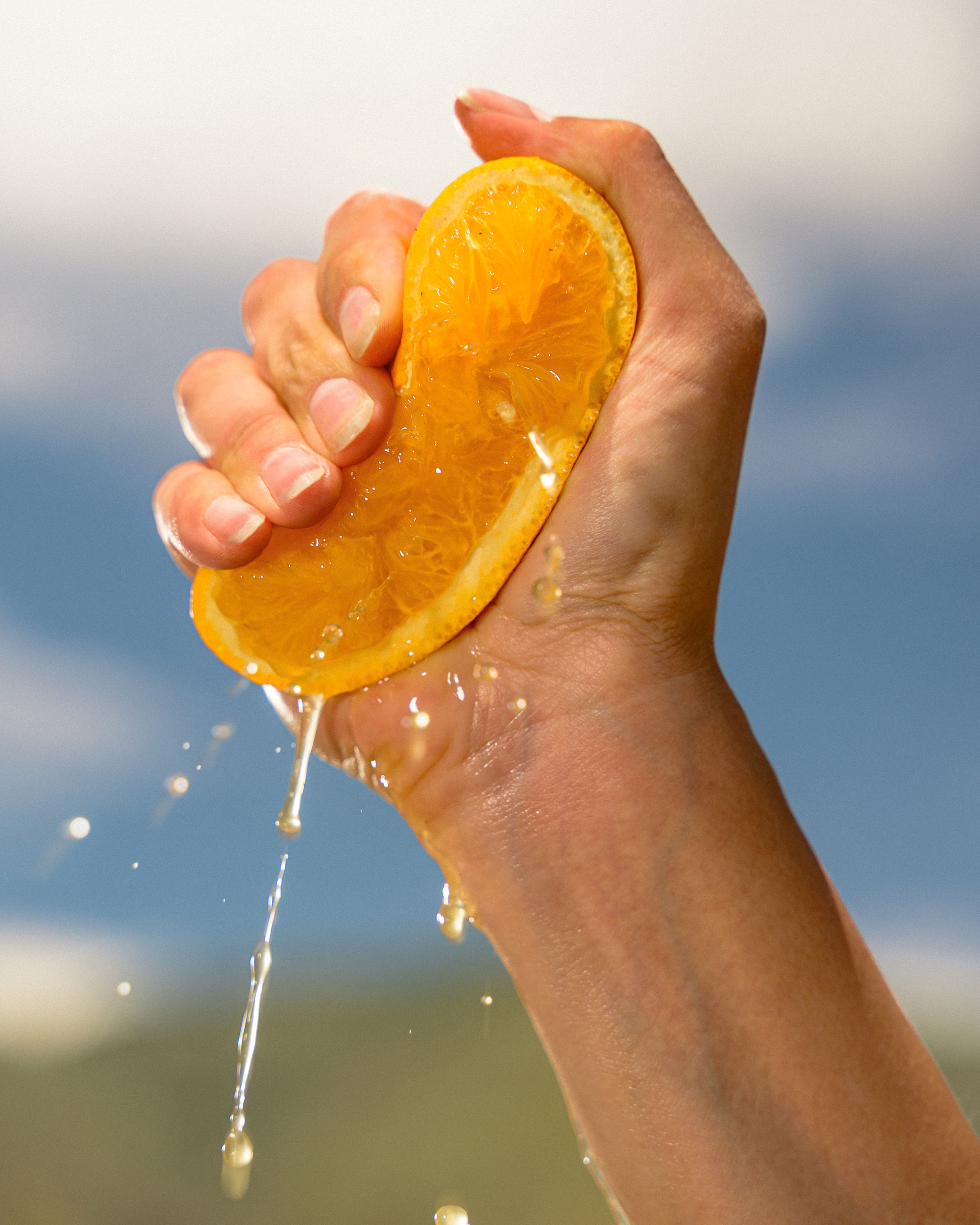 A worker squeezes juice from an orange