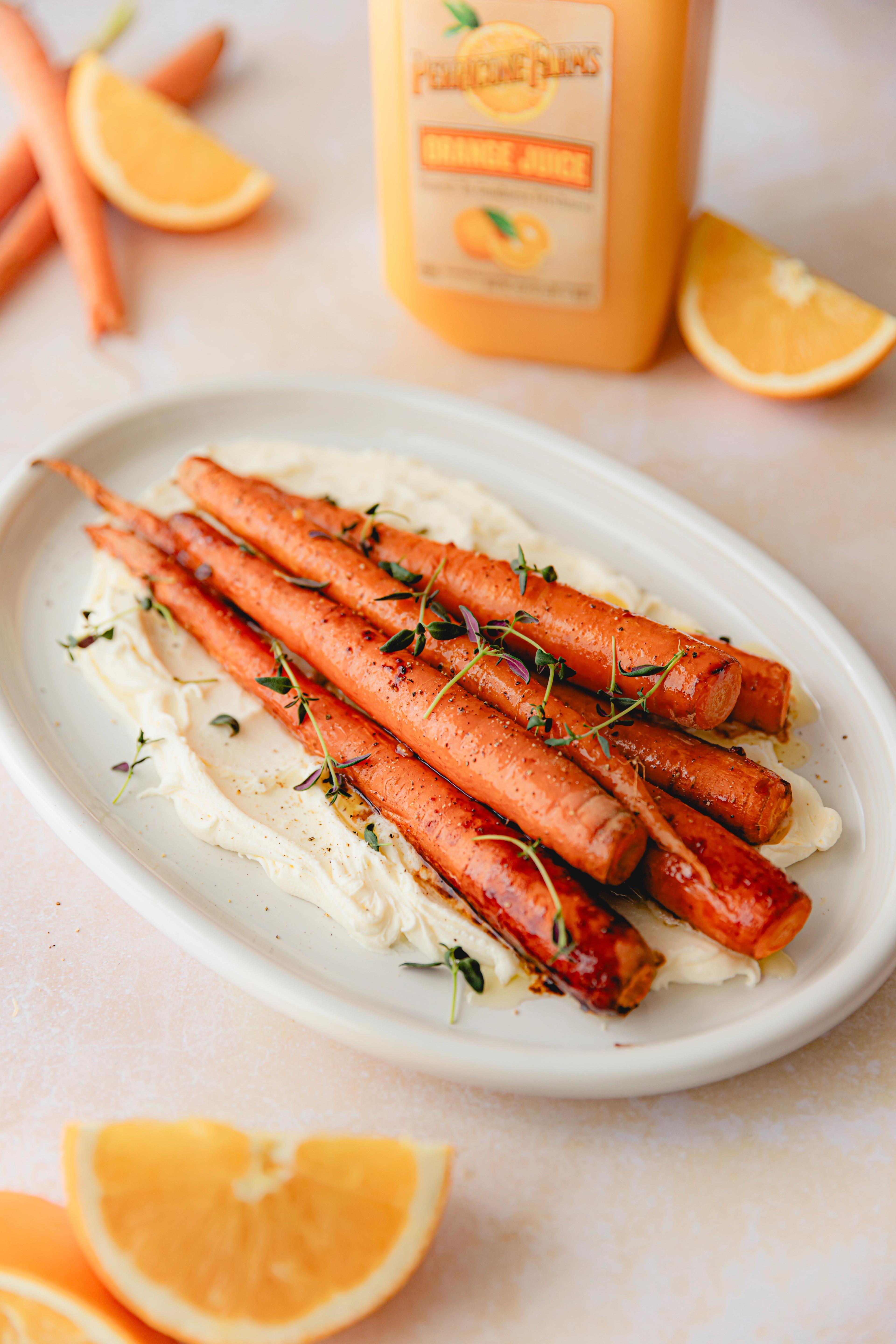 A platter of roasted carrots glazed in Perricone Farms Orange Juice, served over whipped mascarpone and topped with fresh thyme.