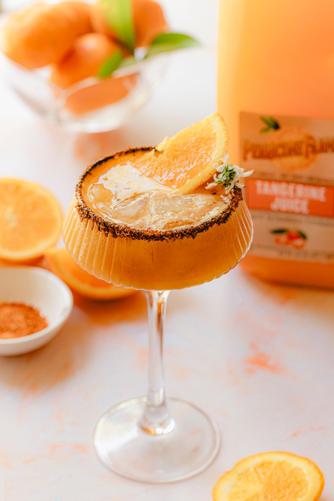 Tamarind & Tangerine Cocktail made with Perricone Farms Tangerine Juice, tequila, and tamarind paste, served over ice in a chili-rimmed glass with citrus garnish