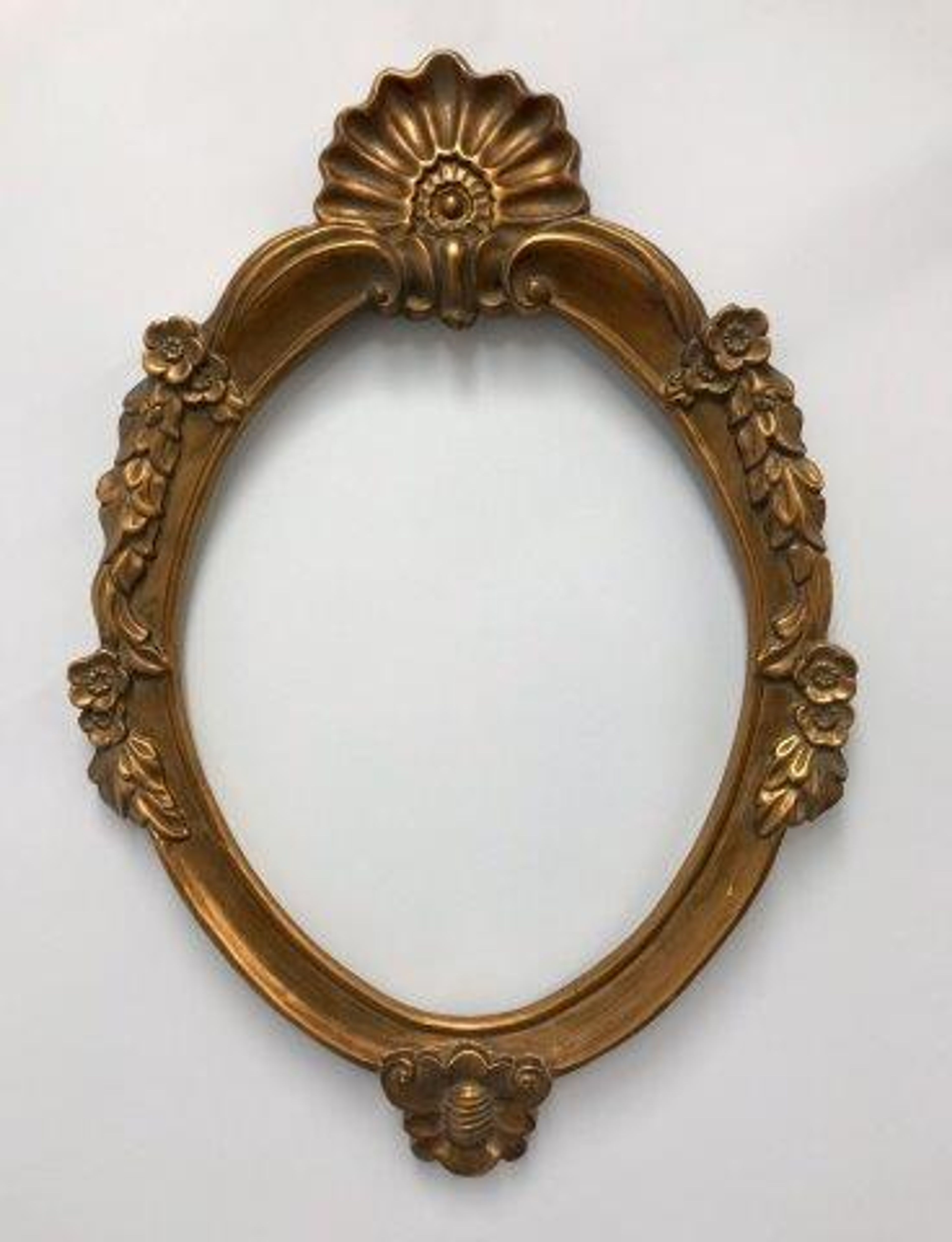 Miroir ovale classique doré orné de motifs floraux