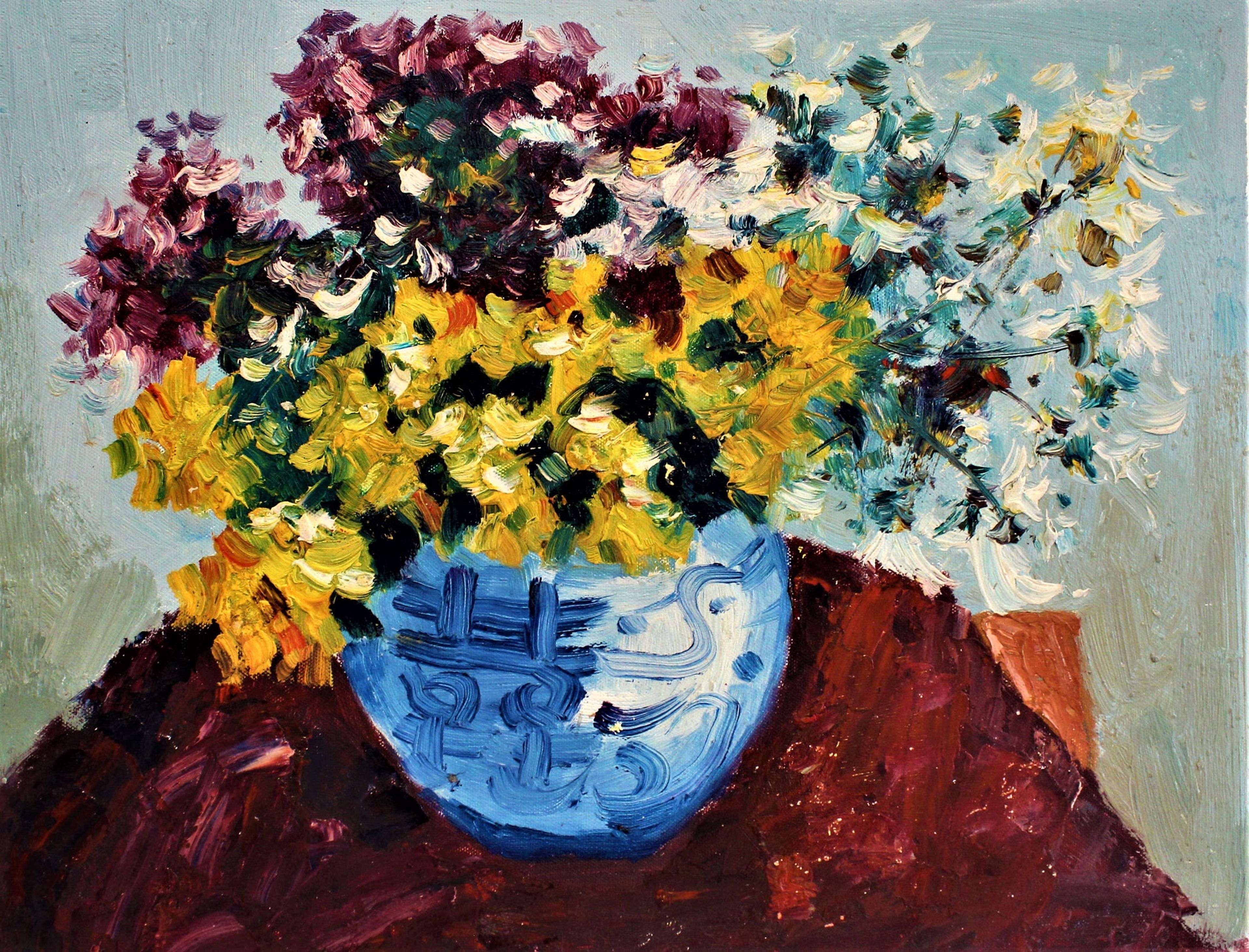 Fleurs violettes, jaunes et blanches dans un vase bleu