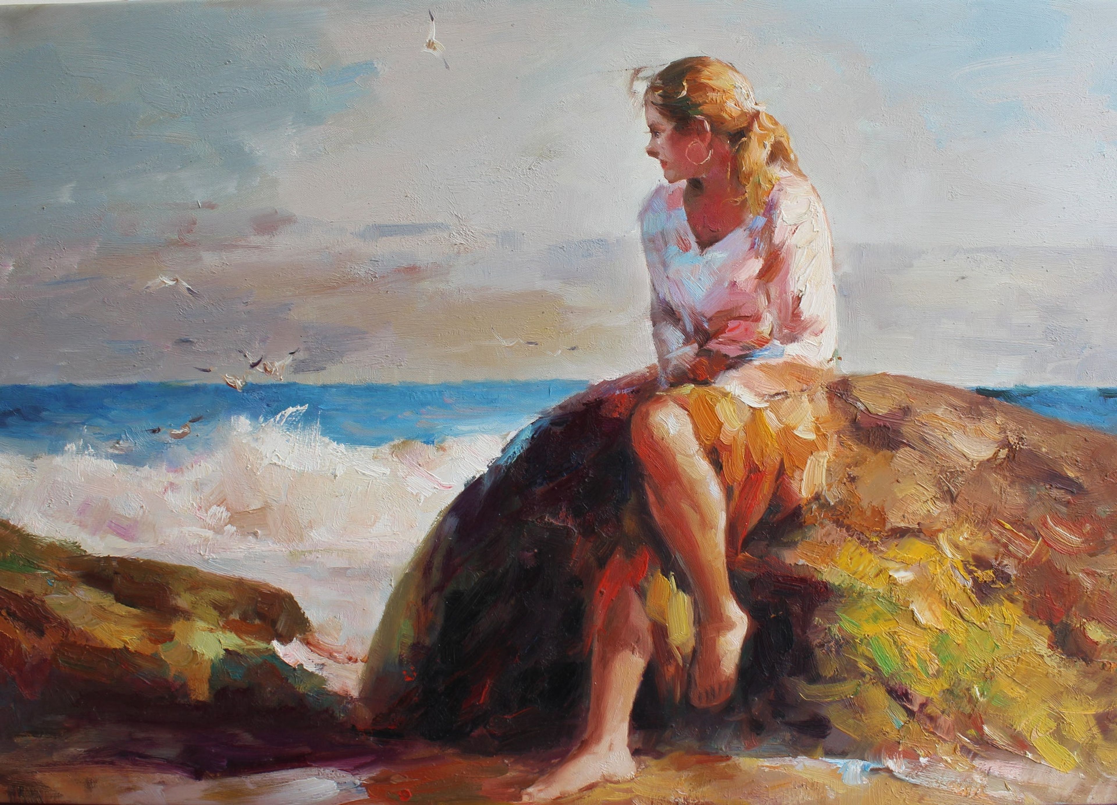 Femme blonde assise au bord de l'océan