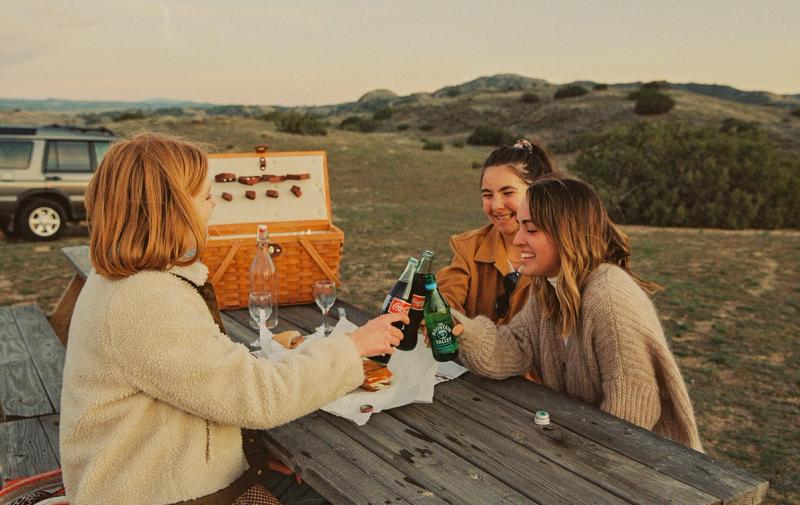 A picnic basket packed on a postcard-style table setting