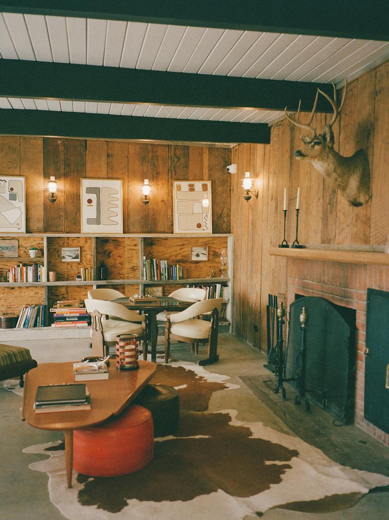 A cozy, decorated room with a fireplace and mounted buck head