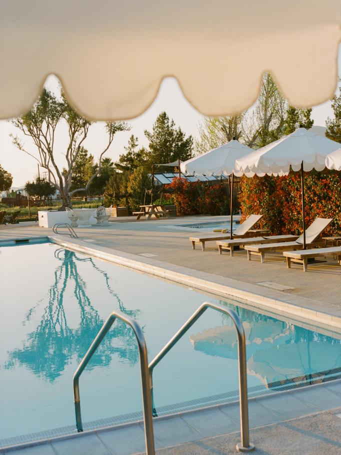 Poolside cabana umbrellas and loungers glowing at golden hour