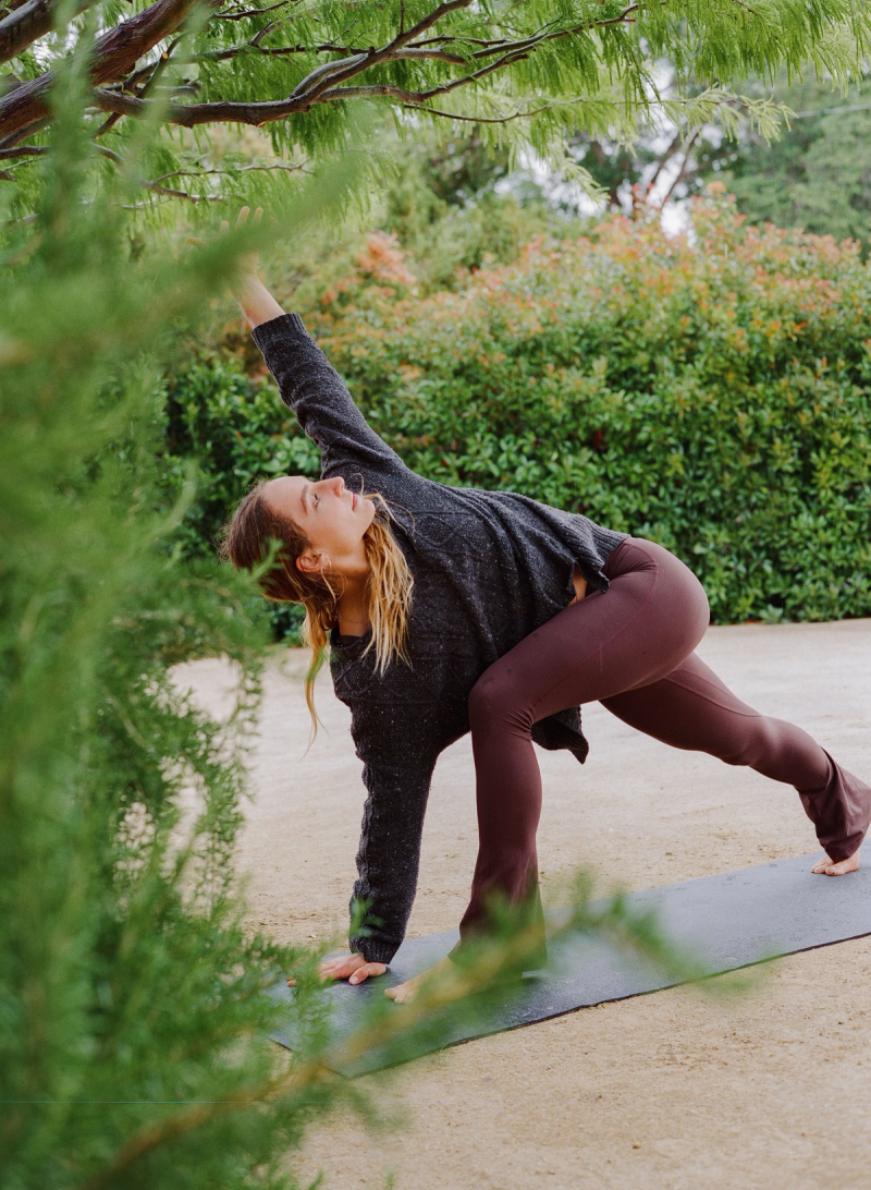 A guest moving through a yoga pose on the lawn at Cuyama Buckhorn