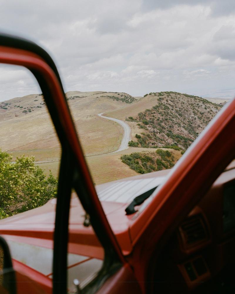 A view of a winding road through the window of a stopped car
