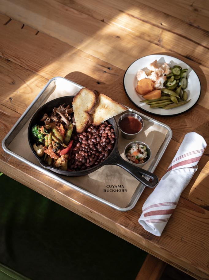 Cast-iron skillet of meat, vegetables and beans with toast on a Cuyama Buckhorn tray