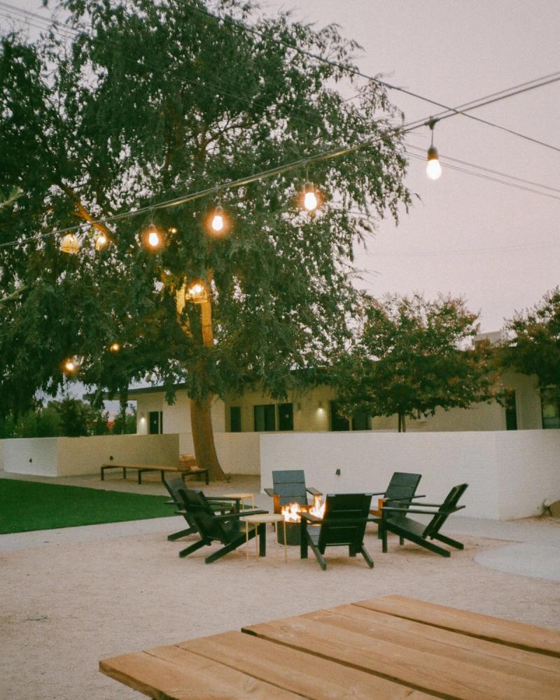 String lights strung through a tree over an evening fire pit lounge