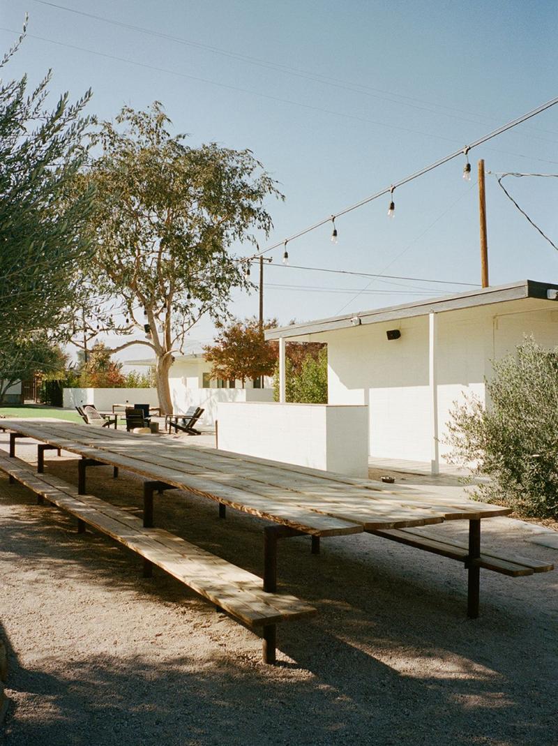 A long picnic table strung with lights beside the motel courtyard