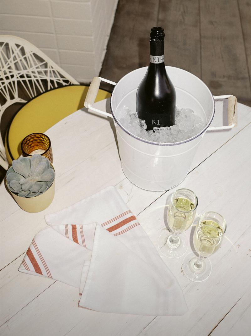 Two glasses of sparkling wine on a striped linen napkin.