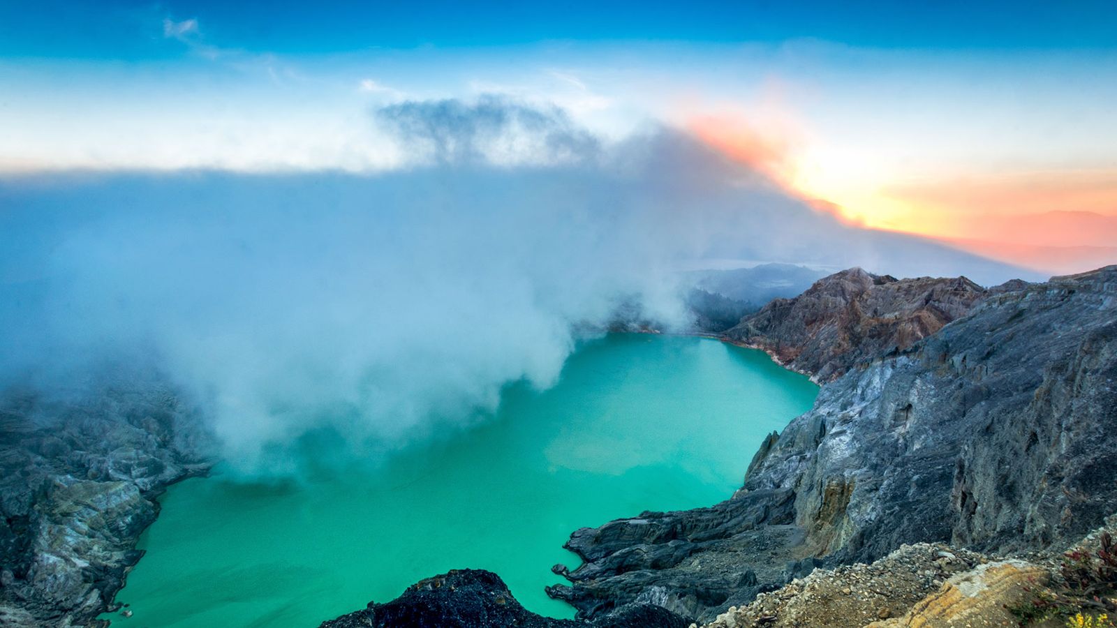 Sunrise over the turquoise acidic crater lake at Kawah Ijen, East Java