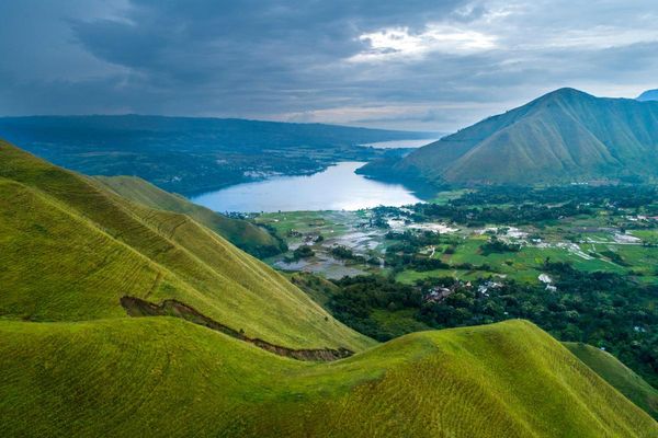 Lake Toba seen from the green hills above the shore, with Batak villages and rice fields below