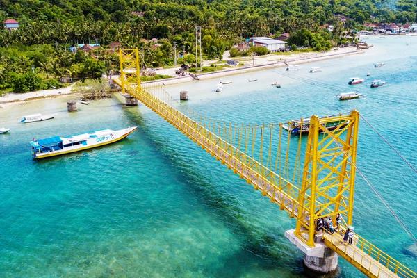 The yellow suspension bridge linking Nusa Lembongan and Nusa Ceningan over a turquoise channel