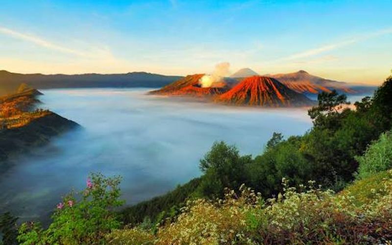 Mount Bromo at sunrise, mist filling the Tengger caldera with the crater smoking and Semeru behind