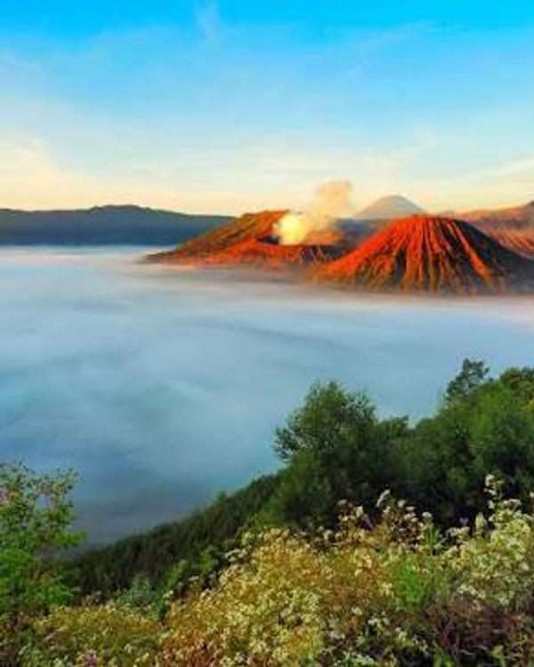 Mount Bromo at sunrise, mist filling the Tengger caldera with the crater smoking and Semeru behind
