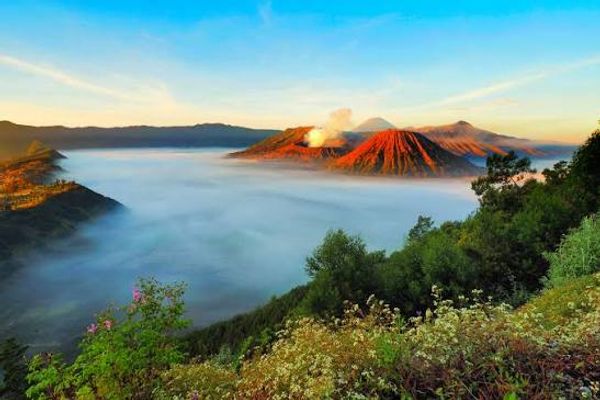 Mount Bromo at sunrise, mist filling the Tengger caldera with the crater smoking and Semeru behind