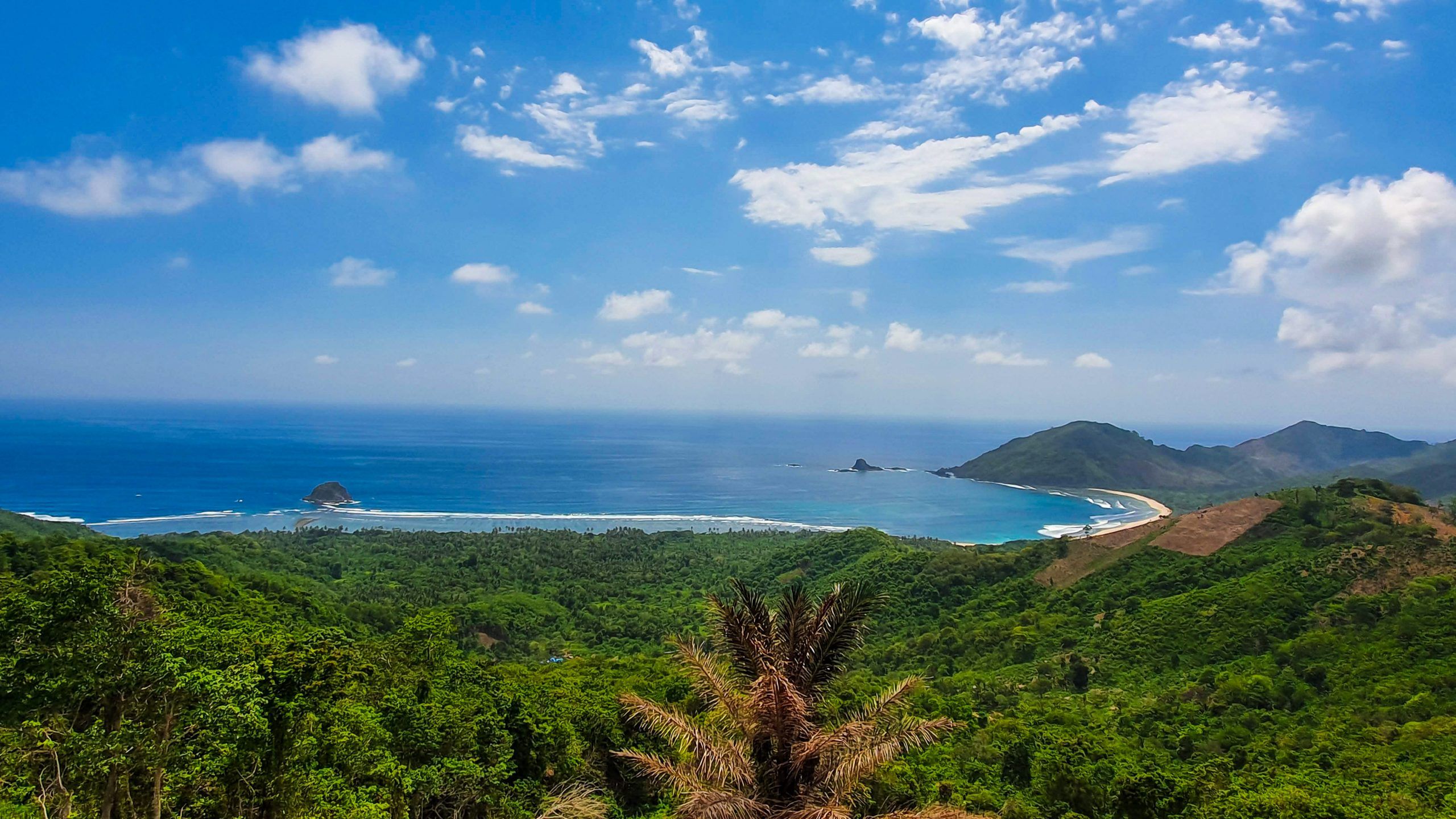Mekaki Bay seen from the hills above Sekotong, southwest Lombok, with an empty beach and green headlands