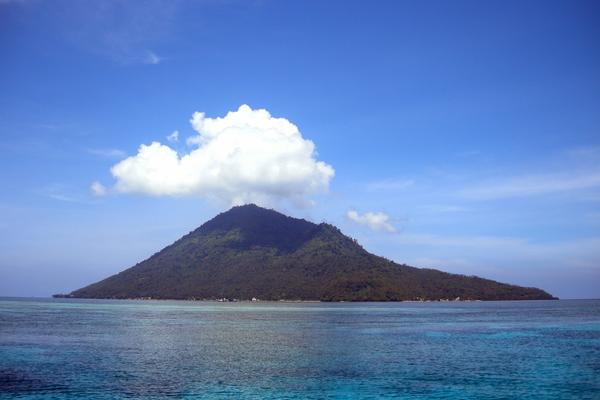Manado Tua volcano rising above the reef water off Bunaken, North Sulawesi