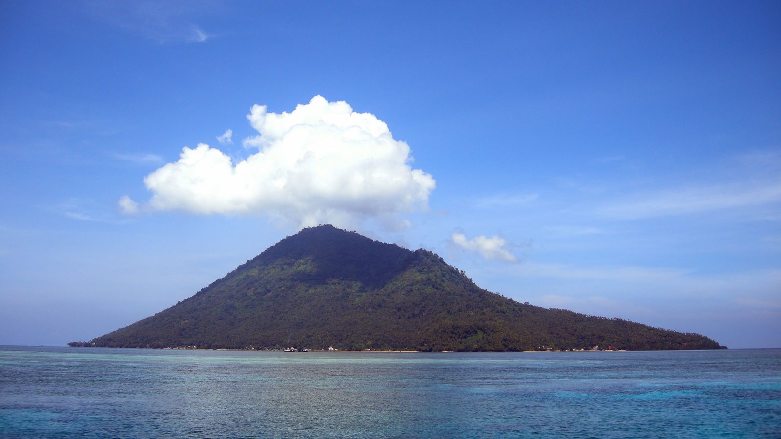 Manado Tua volcano rising above the reef water off Bunaken, North Sulawesi