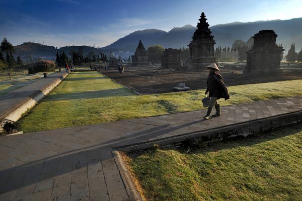 Morning light over the Arjuna temple complex on the Dieng Plateau, Central Java, with the volcanic hills behind