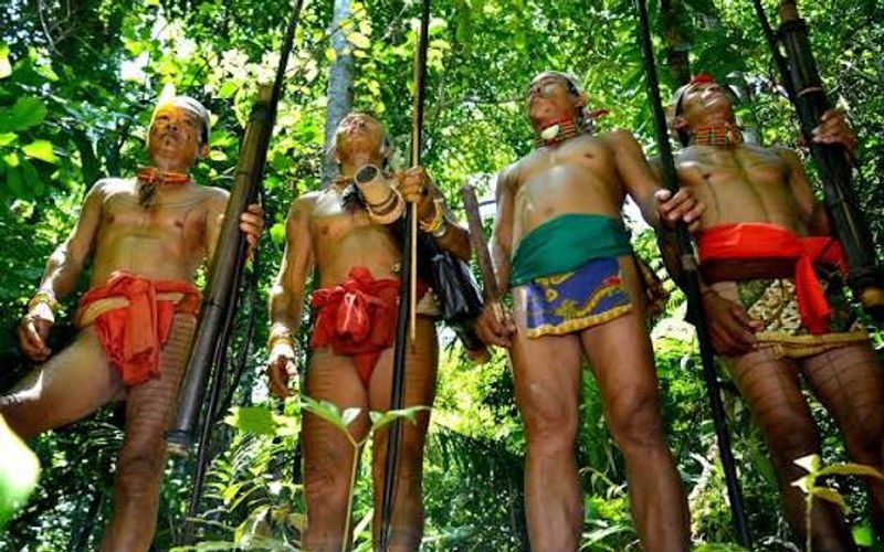 Mentawai men in traditional dress holding hunting bows in the Siberut rainforest