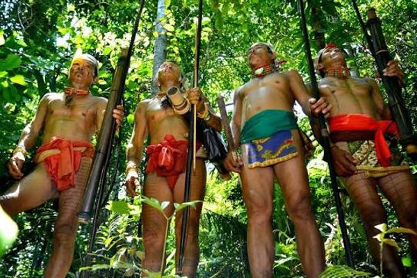 Mentawai men in traditional dress holding hunting bows in the Siberut rainforest