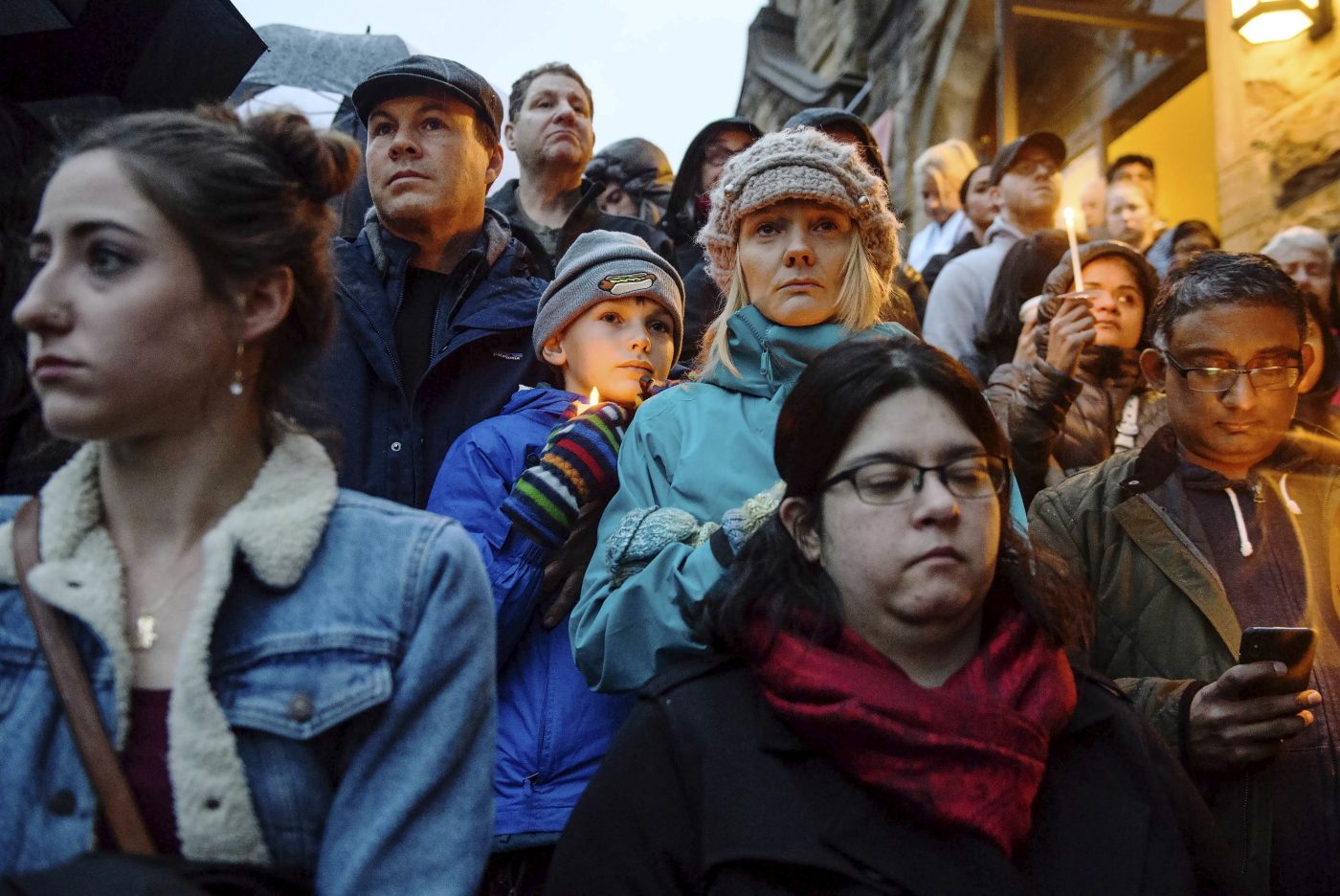 People stand on the stairs of Sixth Presbyterian Church as the crowd spills up the hill and down the street for a vigil blocks from where an active shooter shot multiple people at Tree of Life Congregation synagogue on Saturday, Oct. 27, 2018, in the Squirrel Hill section of Pittsburgh. (Stephanie Strasburg/Pittsburgh Post-Gazette via AP)
