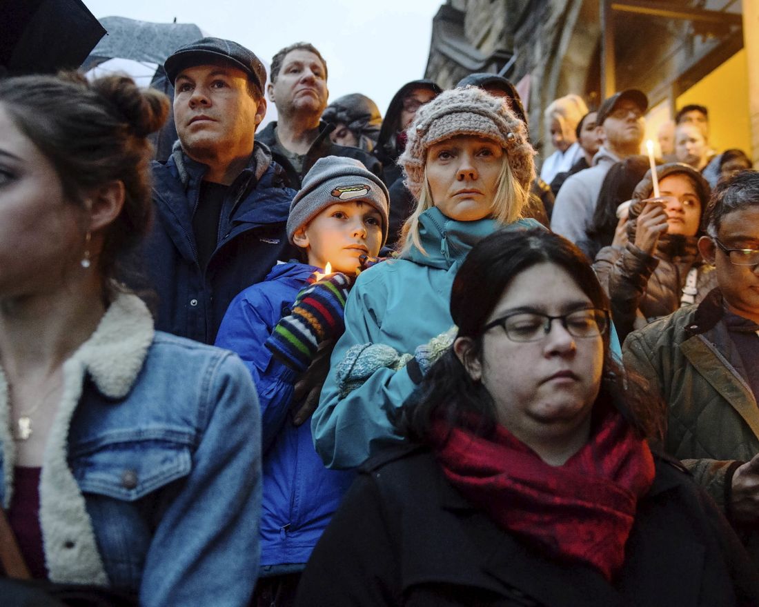 People stand on the stairs of Sixth Presbyterian Church as the crowd spills up the hill and down the street for a vigil blocks from where an active shooter shot multiple people at Tree of Life Congregation synagogue on Saturday, Oct. 27, 2018, in the Squirrel Hill section of Pittsburgh. (Stephanie Strasburg/Pittsburgh Post-Gazette via AP)