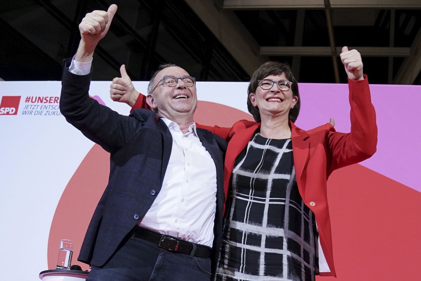 Norbert Walter-Borjans and Saskia Esken wave after the announcement of the result of the vote on the SPD chairmanship in the Willy Brandt House in Berlin, Germany, Saturday, Nov. 30, 2019.  Walter-Borjans and Esken have won the vote. The new leadership will be confirmed at the party conference on December 6. (Kay Nietfeld/dpa via AP)