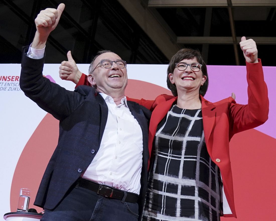 Norbert Walter-Borjans and Saskia Esken wave after the announcement of the result of the vote on the SPD chairmanship in the Willy Brandt House in Berlin, Germany, Saturday, Nov. 30, 2019.  Walter-Borjans and Esken have won the vote. The new leadership will be confirmed at the party conference on December 6. (Kay Nietfeld/dpa via AP)