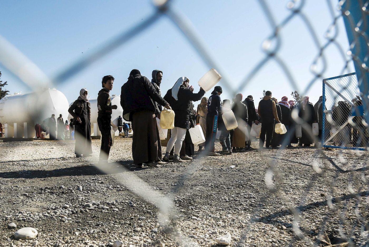 Refugees who fled the Iraqi city of Mosul due to the fighting between government forces and Islamic State (IS) group jihadists, queue for heating fuel at the UN-run al-Hol refugee camp in Syria's Hasakeh province, on January 29, 2017. / AFP PHOTO / DELIL SOULEIMAN