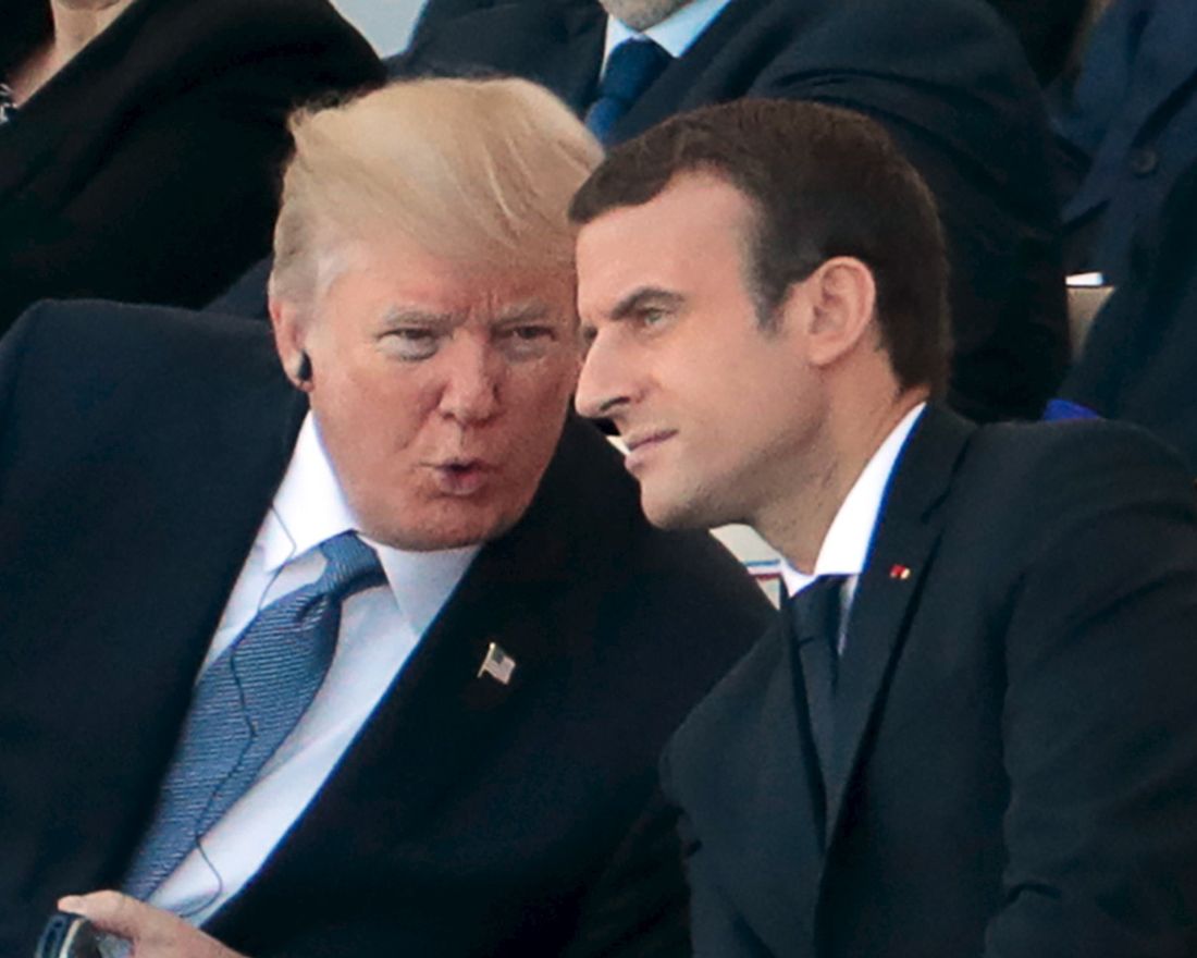 French President Emmanuel Macron (R) listens to US President Donald Trump as they attend the annual Bastille Day military parade on the Champs-Elysees avenue in Paris on July 14, 2017. 
 The parade on Paris's Champs-Elysees will commemorate the centenary of the US entering WWI and will feature horses, helicopters, planes and troops. / AFP PHOTO / joel SAGET