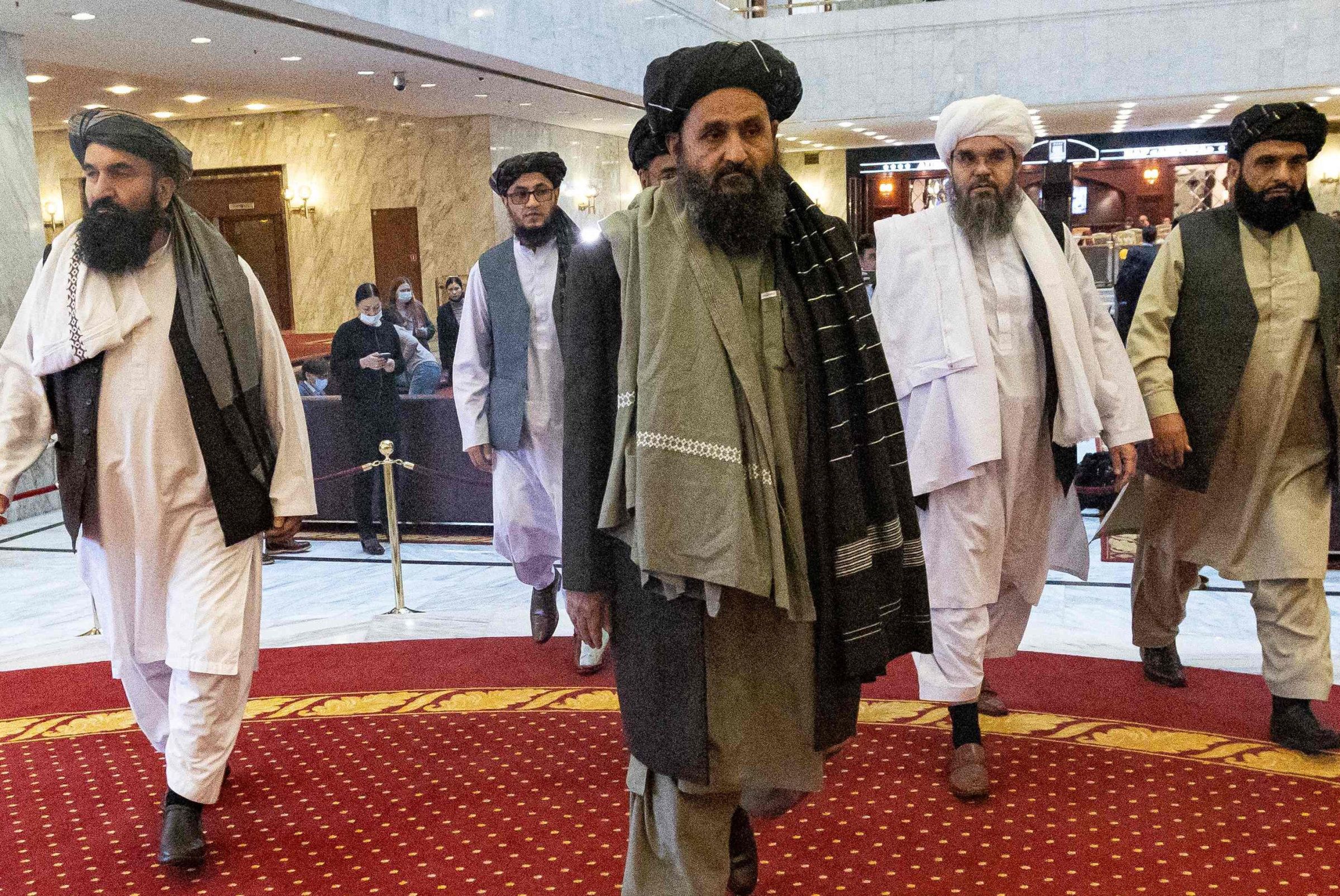 Taliban co-founder Mullah Abdul Ghani Baradar (C) and other members of the Taliban delegation arrive to attend an international conference on Afghanistan over the peaceful solution to the conflict in Moscow on March 18, 2021. (Photo by Alexander Zemlianichenko / POOL / AFP)