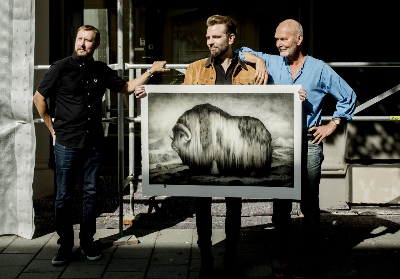 F.v. Petter U. Morken, Daglig leder Kunstverket galleri, kunstnerne Sverre Malling og Arne Bendik Sjur. Åpner ny utstilling på Kunstverket. De mener det for tiden "spys" ut grafikk av rent kommersielle hensyn, og tar til orde for å fremme grafikk som selvstendig medium. På bildet holder kunstnerne opp Sverre Mallings "Moskus" som er et av bildene til salgs.