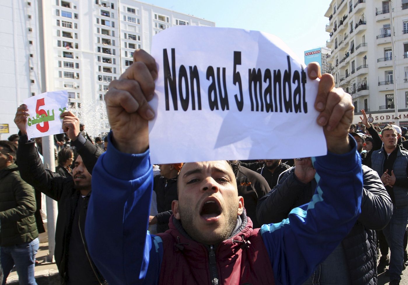 A protester holds up a leaflet reading : "No to a 5th term" during a demonstration to denounce President Abdelaziz Bouteflika's bid for a fifth term, in Algiers, Algeria, Friday, Feb. 23, 2019. The 81-year-old Bouteflika announced this month that he plans to seek a new term in April presidential elections despite serious questions over his fitness for office after a 2013 stroke left him largely infirm. (AP Photo/Anis Belghoul)