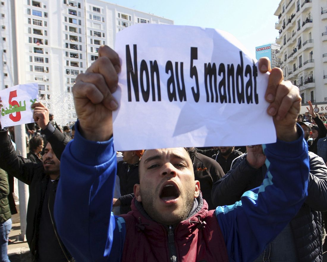 A protester holds up a leaflet reading : "No to a 5th term" during a demonstration to denounce President Abdelaziz Bouteflika's bid for a fifth term, in Algiers, Algeria, Friday, Feb. 23, 2019. The 81-year-old Bouteflika announced this month that he plans to seek a new term in April presidential elections despite serious questions over his fitness for office after a 2013 stroke left him largely infirm. (AP Photo/Anis Belghoul)