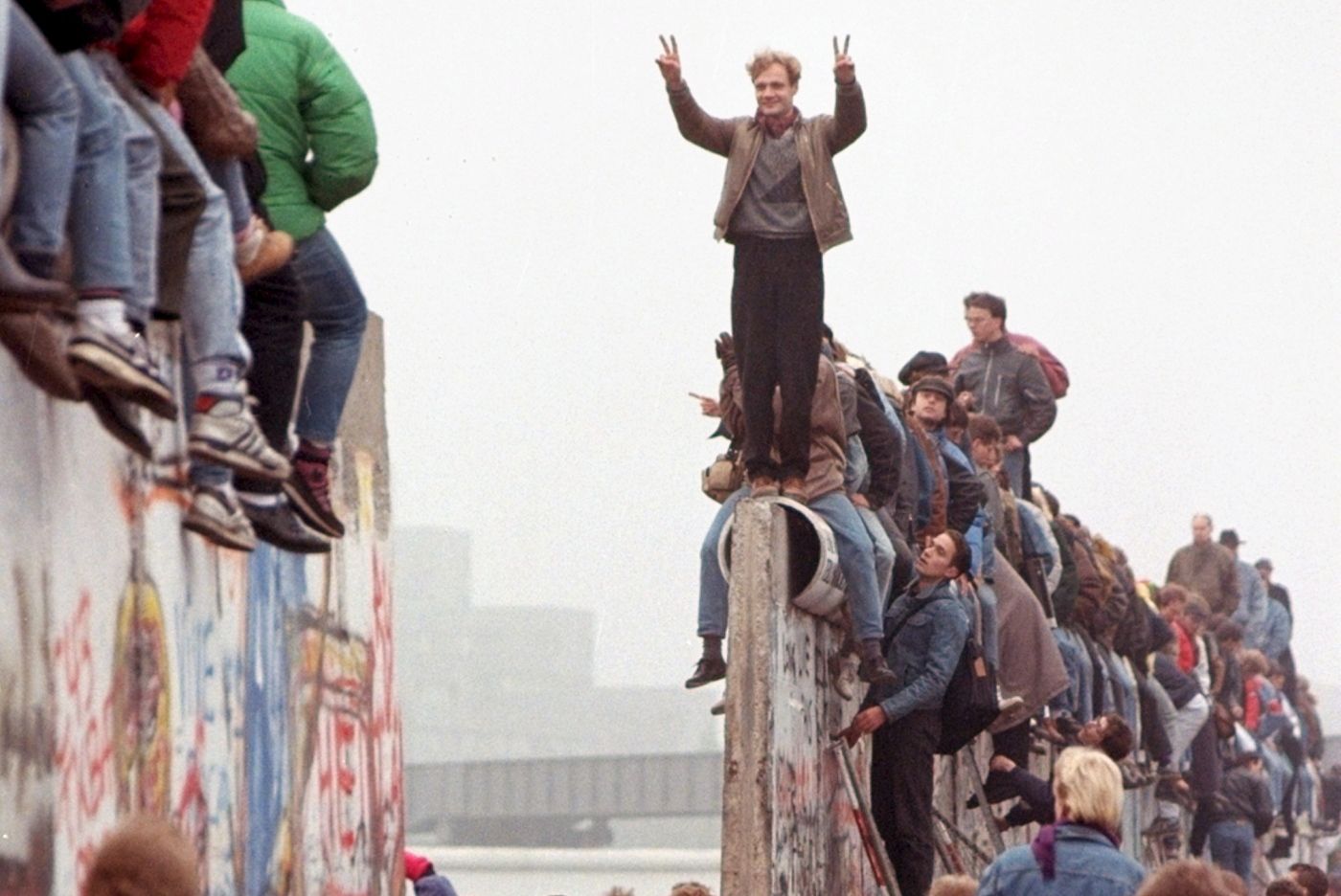 FILE - In this Sunday, Nov. 12, 1989 file photo, Berliners celebrate on top of the wall as East Germans flood through the dismantled Berlin Wall into West Berlin at Potsdamer Platz. When the Berlin Wall fell, the Soviet Union stepped back, letting East Germany's communist government collapse and then quickly accepting German unification. (AP Photo/Lionel Cironneau, File)