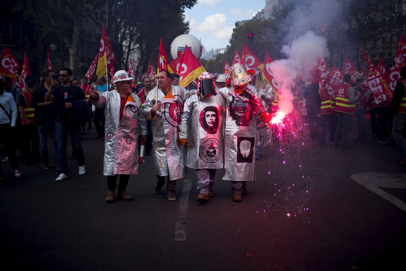 TOPSHOT - Metalworkers demonstrate as they march with flares, banners and flags in the streets of Paris on October 13, 2017. 
 Several thousand workers have taken part in a protest organised by French union CGT for the metallurgy industry in Paris on October 13 to demand a national collective "high level" agreement  for the branch in France. / AFP PHOTO / MARTIN BUREAU