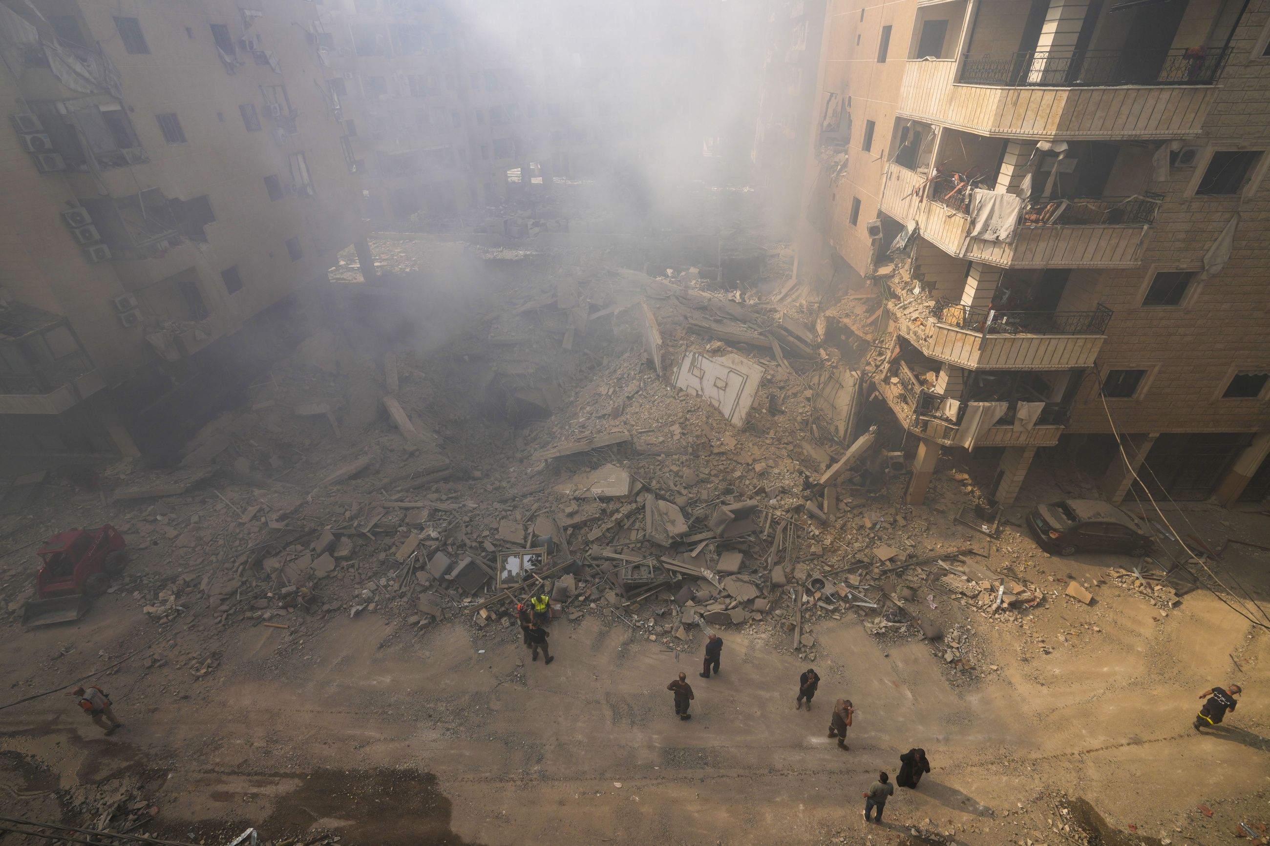 RUIN: Redningsarbeidere søker gjennom ruinene av en boligblokk etter et israelsk luftangrep mot Beiruts sørlige forsteder i går.