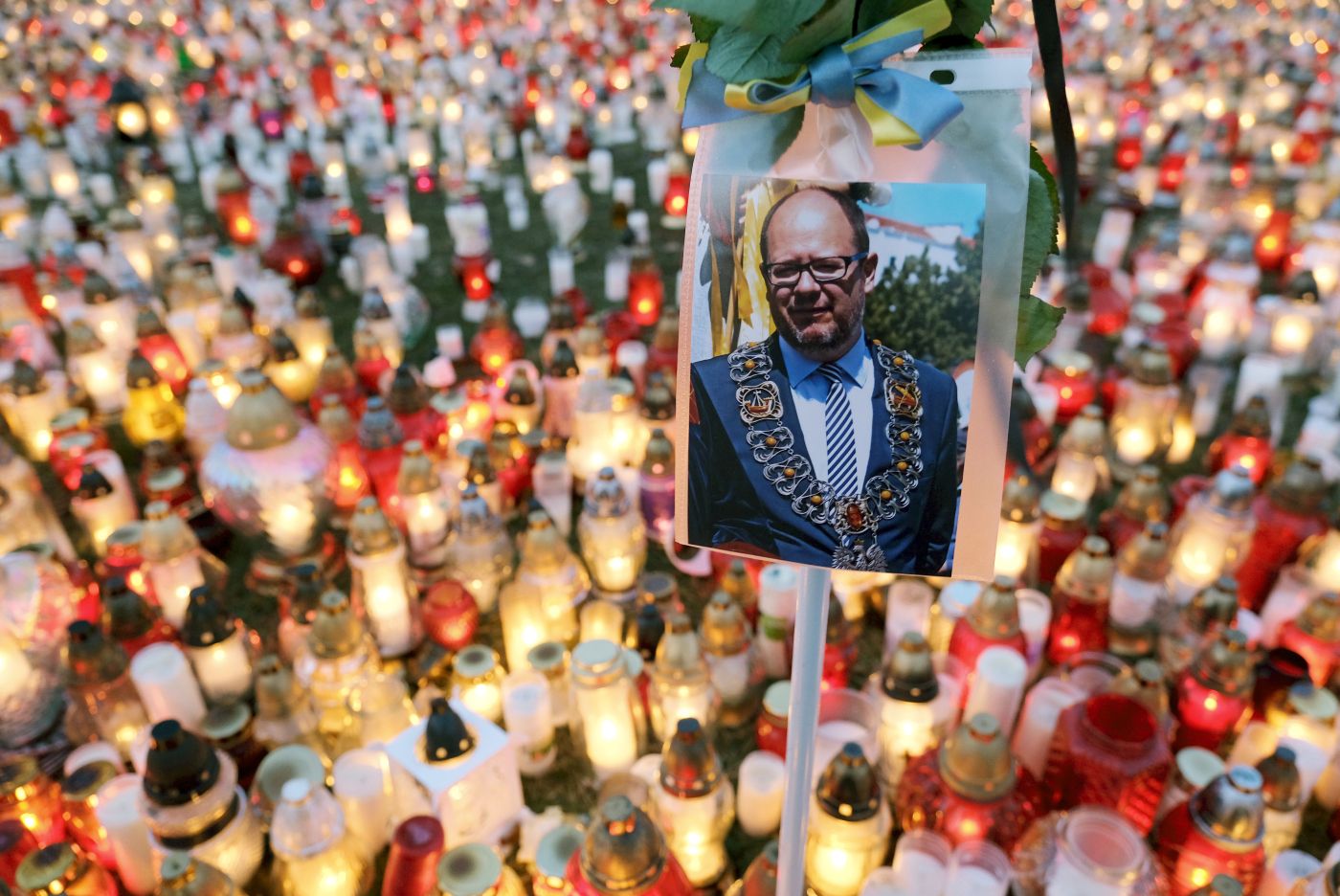 GDANSK, POLAND - JANUARY 17: A photograph of murdered Gdansk mayor Pawel Adamowicz hangs over a sea of candles left by mourners on January 17, 2019 in Gdansk, Poland. Adamowicz was stabbed on stage while attending a charity event in Gdansk last Sunday and died a day later of his injuries. The suspect is a 27-year-old man with a criminal record who was taken into custody. The coffin carrying Adamowicz's body is to be displayed in the European Solidarity Centre later today, where the public may come to pay last respects. Adamowicz's funeral is scheduled for Saturday.  (Photo by Sean Gallup/Getty Images)